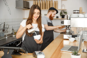 mujer echando leche al cafe